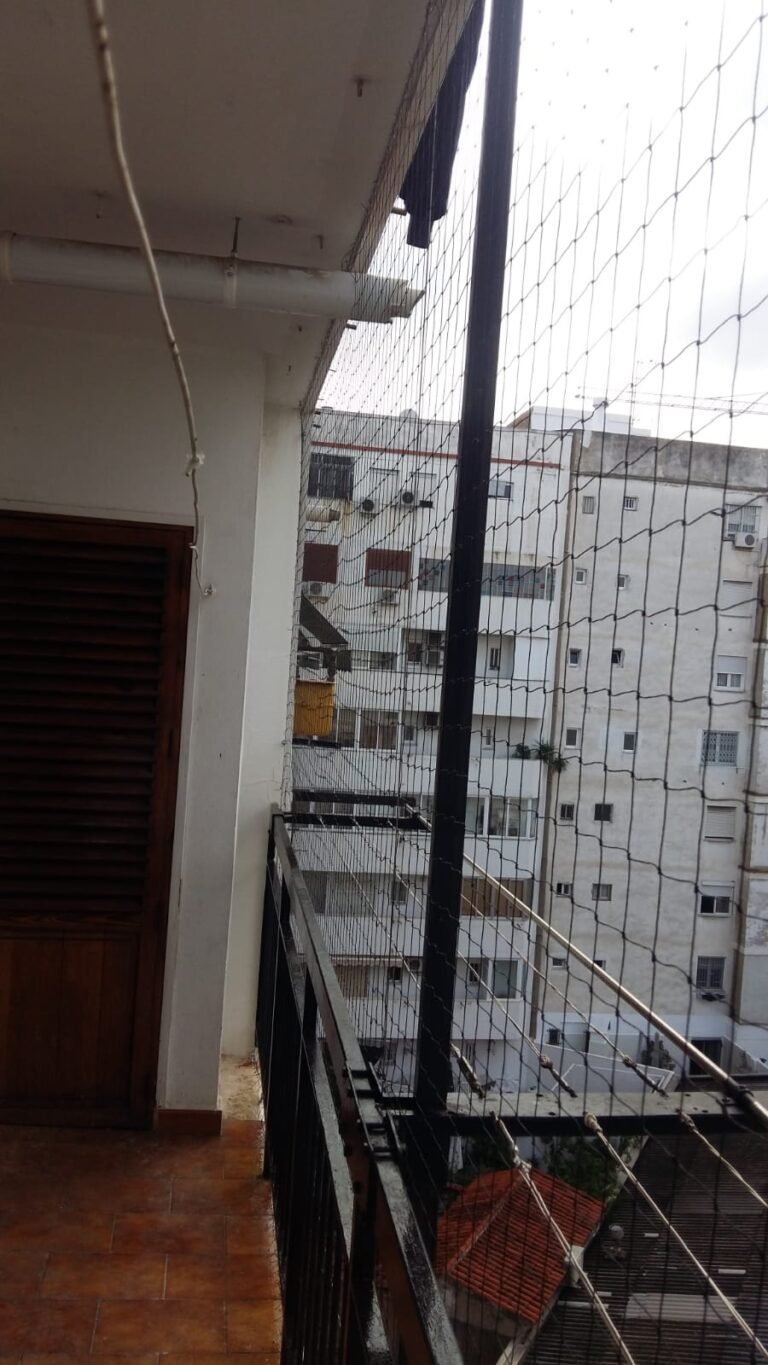 Red tensada con poste y anclajes en un balcón